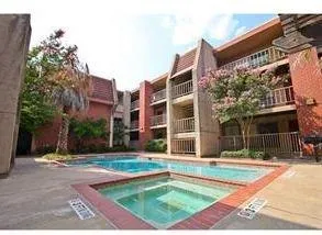 a view of a balcony with wooden floor & fence
