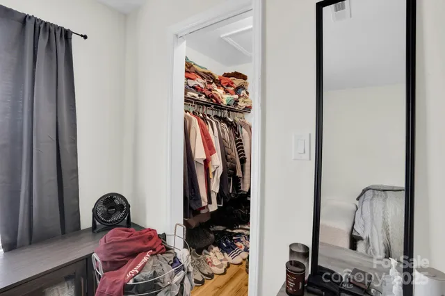 a view of walk in closet with clothes and shoes