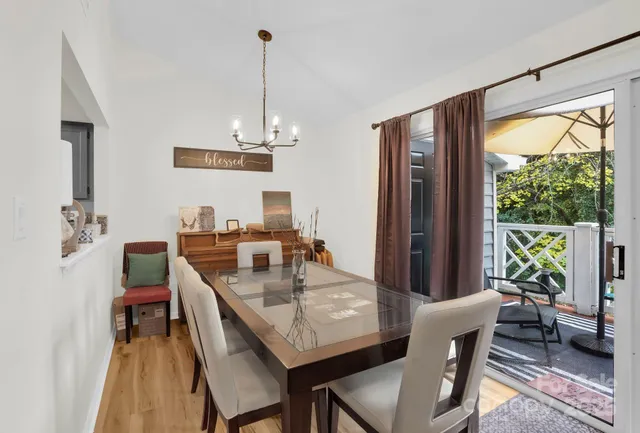 a dining room with furniture a chandelier and wooden floor