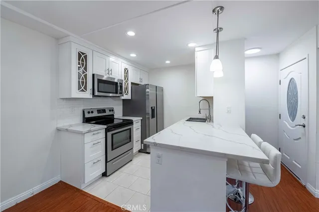 a kitchen with kitchen island a sink stainless steel appliances and cabinets