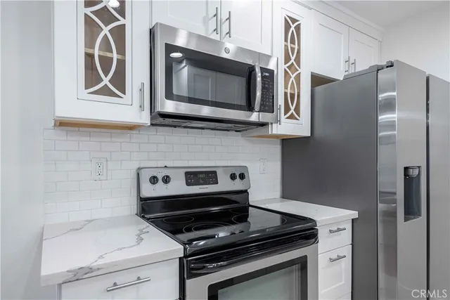 a kitchen with stainless steel appliances a stove microwave and refrigerator