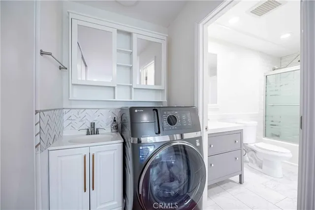 a utility room with sink dryer and washer