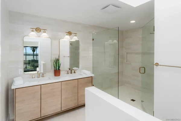 a bathroom with a double vanity sink mirror and bathtub