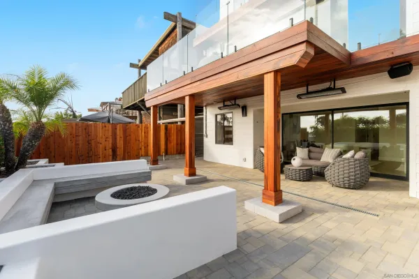 a living room with couches and kitchen view with wooden floor