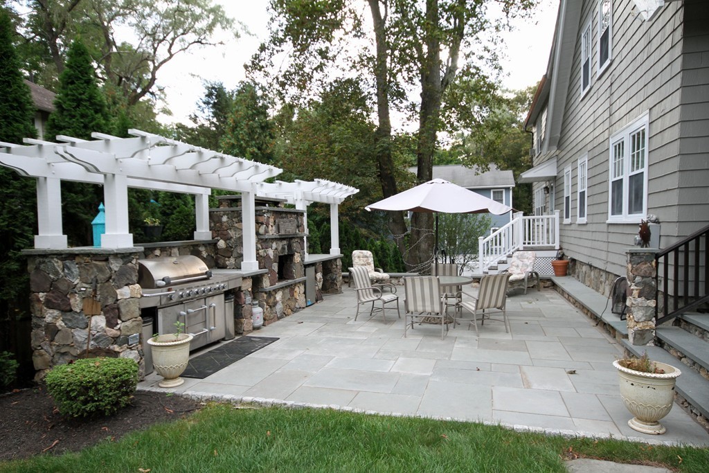 1 Stevens Road Wellesley, MA 02482 - Photo 17 of 18 a view of a patio with a table and chairs under an umbrella
