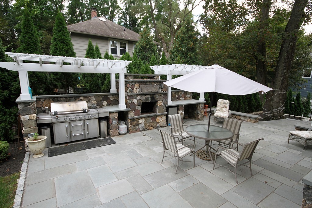 1 Stevens Road Wellesley, MA 02482 - Photo 18 of 18 a patio with a table and chairs under an umbrella