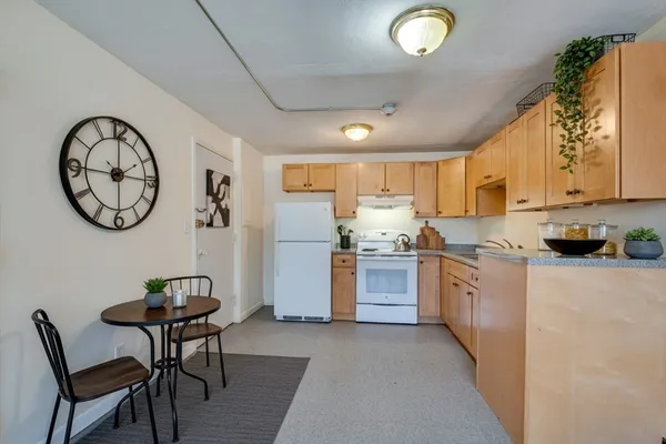 a kitchen with granite countertop a sink cabinets stainless steel appliances and a window