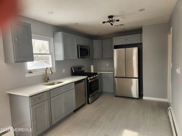 a kitchen with a sink a refrigerator and a window