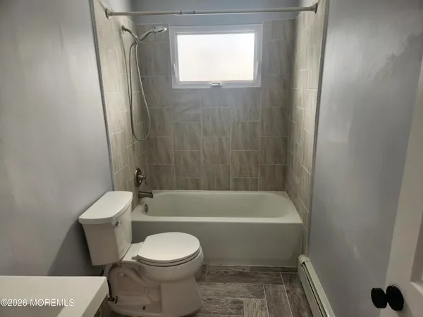 a bathroom with a toilet and a bath tub