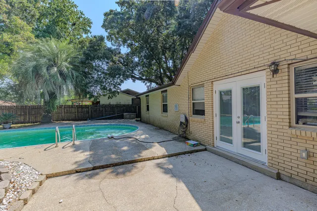 a view of a white house with a small yard and large tree