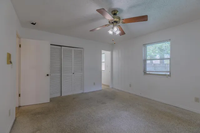 a view of an empty room with a chandelier fan