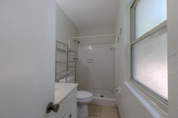 a bathroom with a granite countertop toilet and a shower