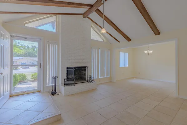 a view of an empty room with a fireplace and a window