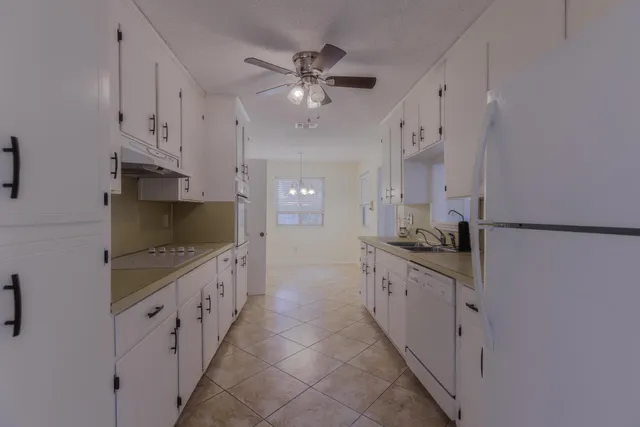 a kitchen with granite countertop a sink and a stove top oven