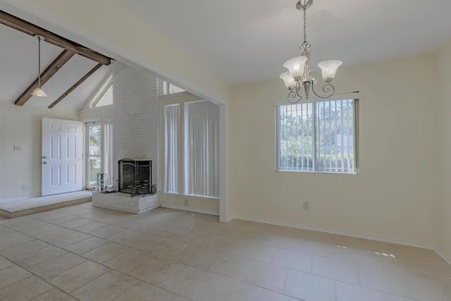 a view of a livingroom with a chandelier a fireplace and window