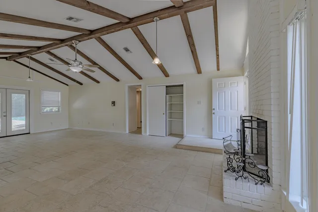 a view of a hallway with wooden table and chairs