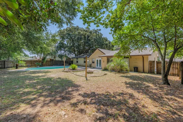 a view of a house with backyard and a tree