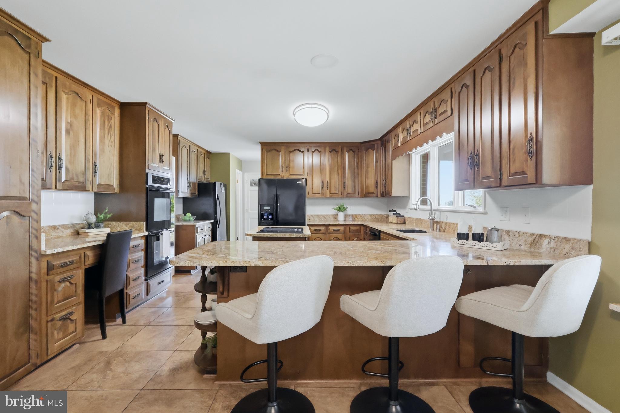 23500 River Road Lexington Park, MD 20653 - Photo 17 of 92 a kitchen with stainless steel appliances kitchen island granite countertop a stove a sink dishwasher a dining table and chairs with wooden floor