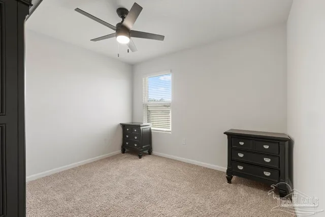 an empty room with windows and ceiling fan