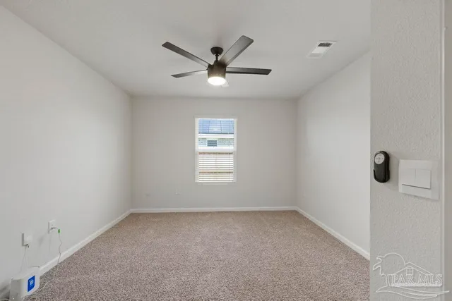an empty room with a window and a fan