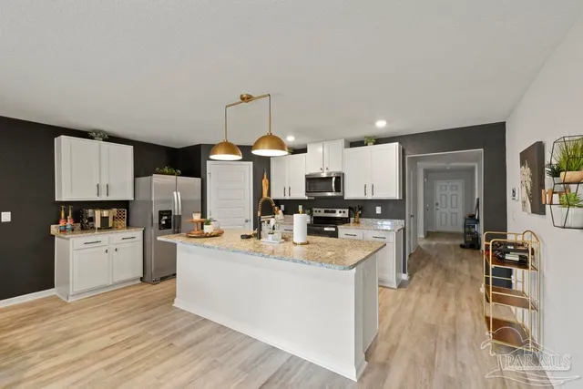 a kitchen with a sink a counter top space stainless steel appliances and cabinets
