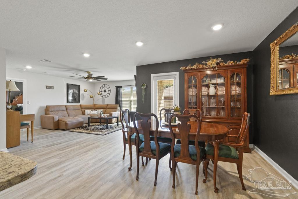 9336 Tara Circle Milton, FL 32583 - Photo 36 of 45 a view of a dining room with furniture and wooden floor