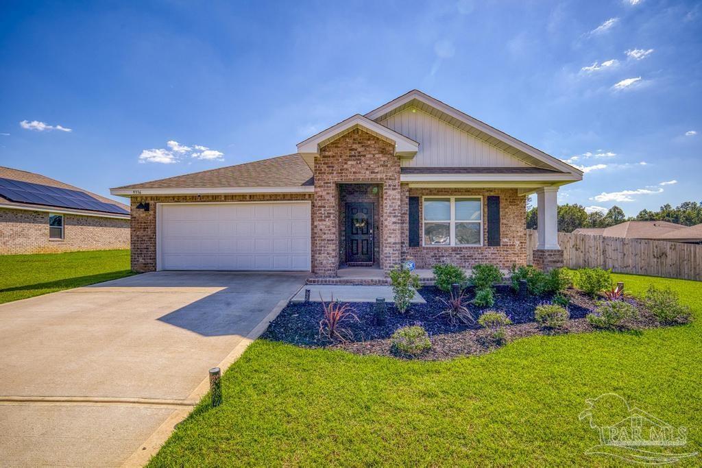 9336 Tara Circle Milton, FL 32583 - Photo 7 of 45 a front view of a house with a garden and plants
