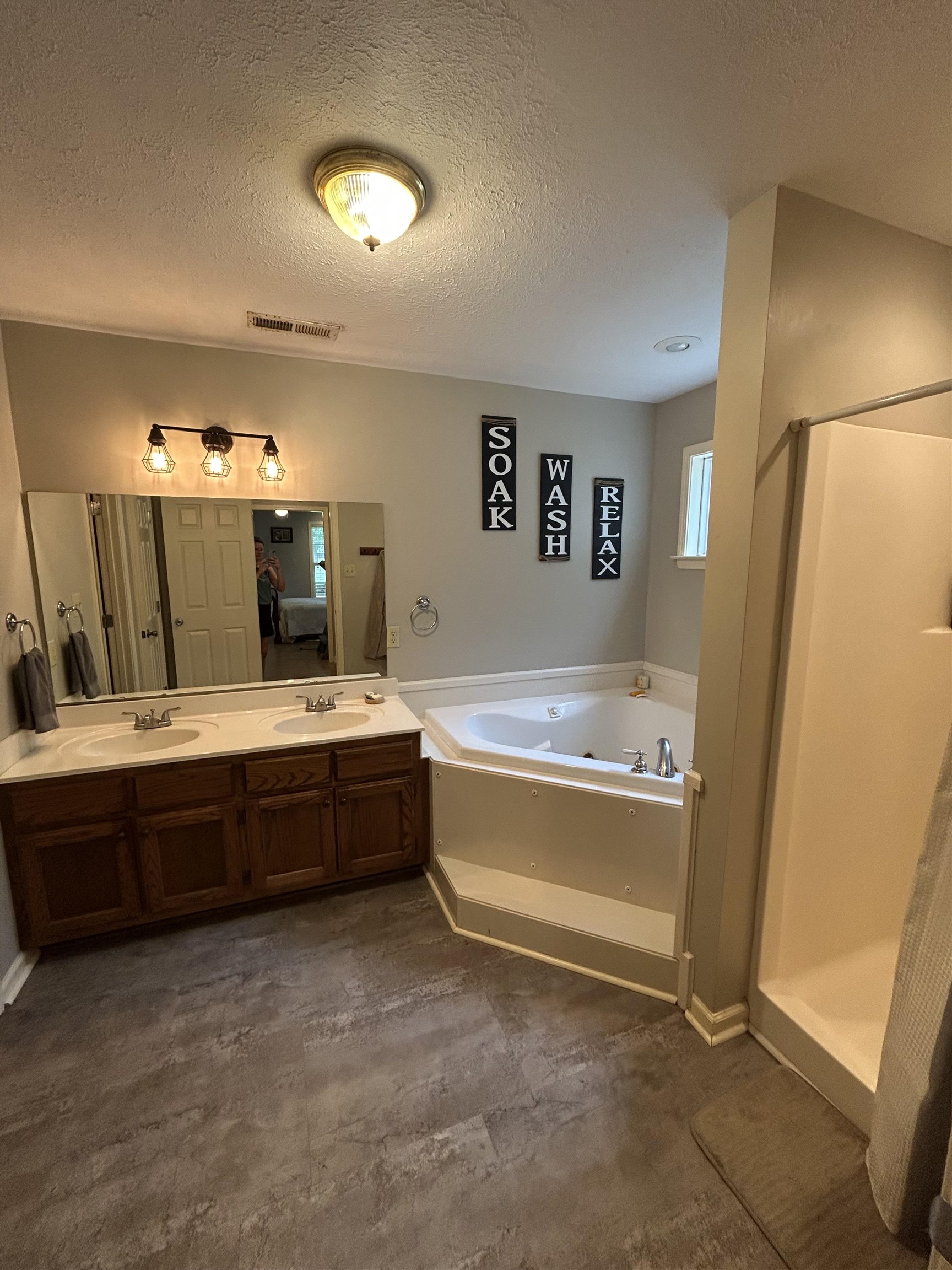 20 Pennington Road Halls, TN 38040 - Photo 16 of 27 Corner jetted tub, wood-finish double vanity with dual sinks, overhead vanity lighting, and recessed ceiling lighting