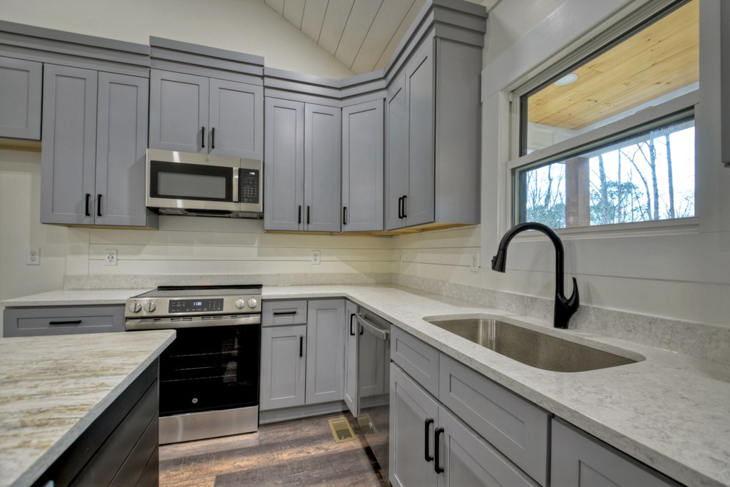 76 Cypress Circle Ellijay, GA 30540 - Photo 14 of 35 a kitchen with granite countertop a sink a stove and cabinets