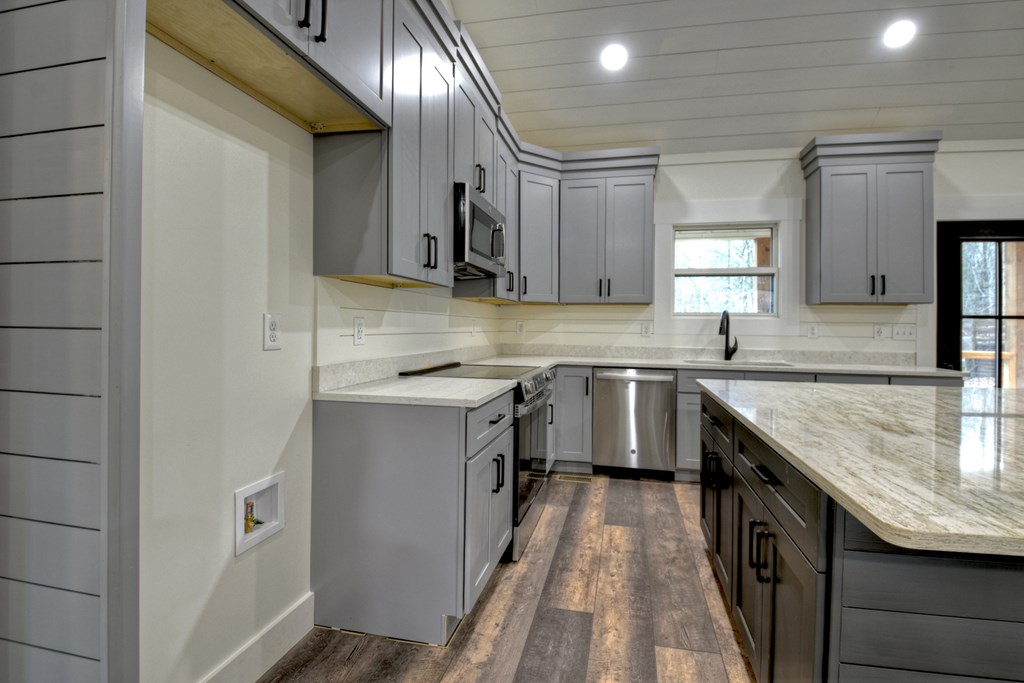 76 Cypress Circle Ellijay, GA 30540 - Photo 15 of 35 a kitchen with a sink dishwasher a stove top oven a refrigerator with island and cabinets