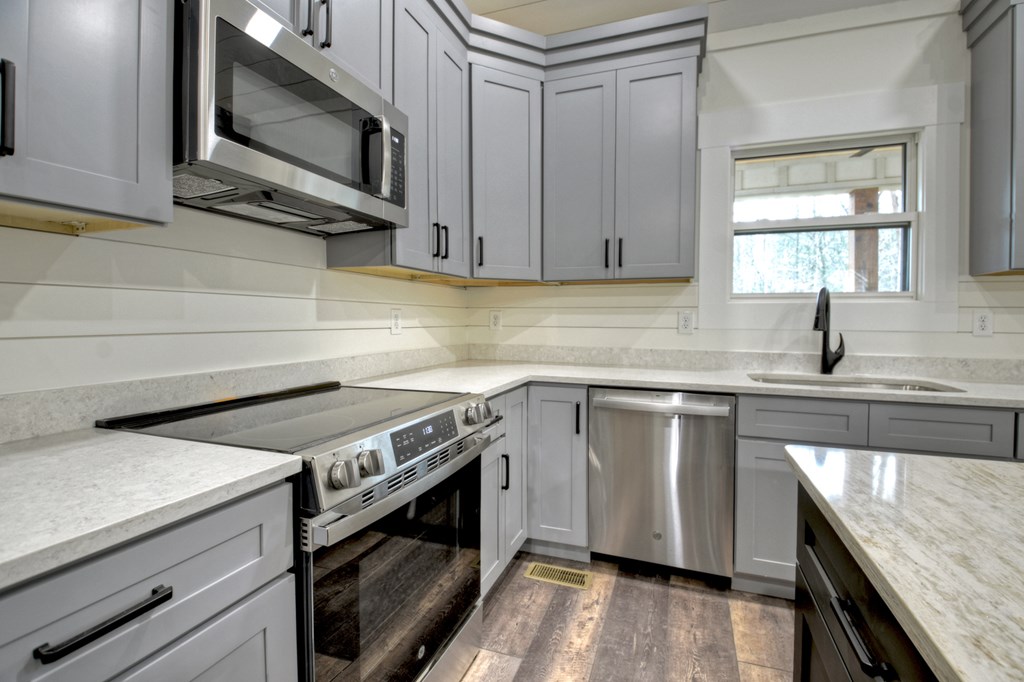 76 Cypress Circle Ellijay, GA 30540 - Photo 17 of 35 a kitchen with stainless steel appliances granite countertop a sink a stove a microwave and wooden cabinets
