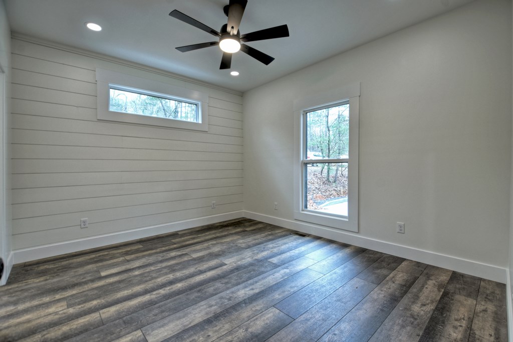 76 Cypress Circle Ellijay, GA 30540 - Photo 22 of 35 an empty room with wooden floor chandelier fan and windows