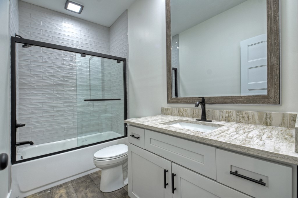 76 Cypress Circle Ellijay, GA 30540 - Photo 23 of 35 a bathroom with a granite countertop sink toilet a mirror and shower