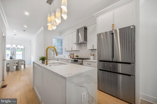 a kitchen with stainless steel appliances granite countertop a sink cabinets and wooden floor