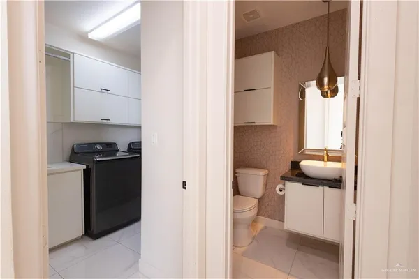 a bathroom with a granite countertop sink and a toilet