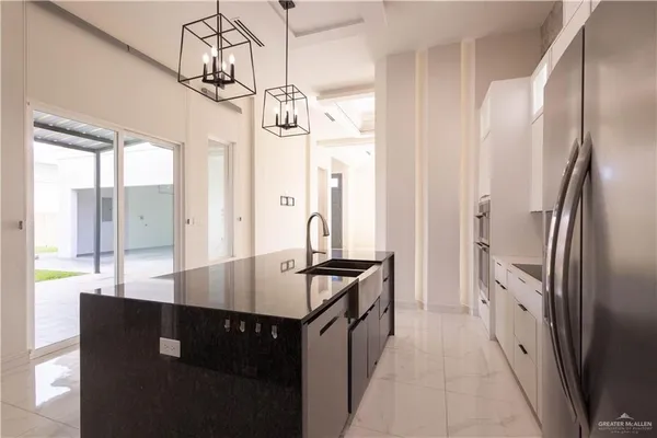 a kitchen with stainless steel appliances granite countertop a refrigerator a sink and dishwasher