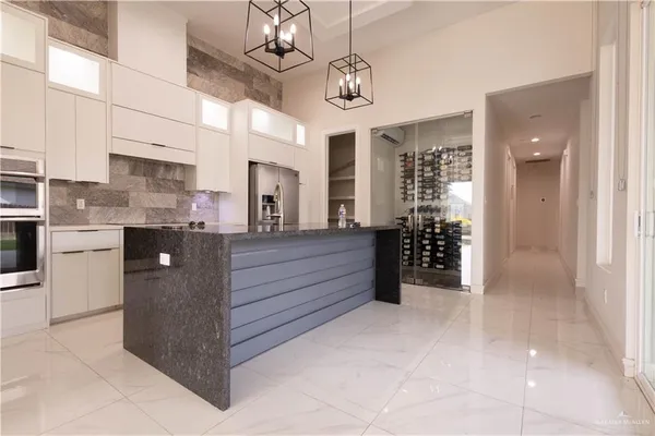 a large kitchen with stainless steel appliances granite countertop a refrigerator and a stove top oven