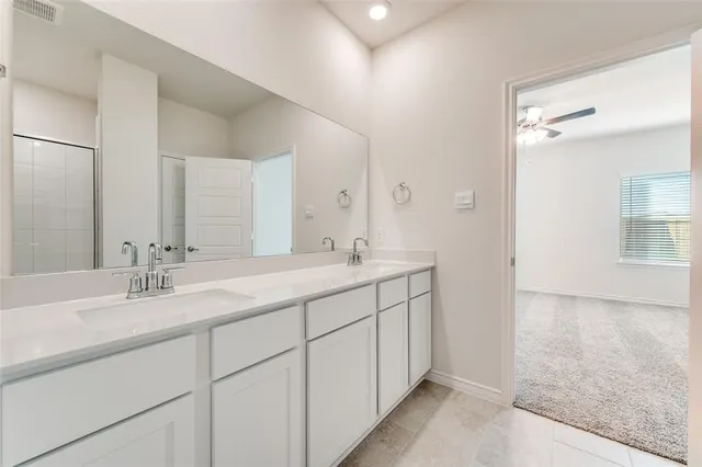 a bathroom with double sink and a mirror