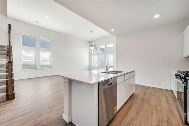 a kitchen with a sink and wooden floor
