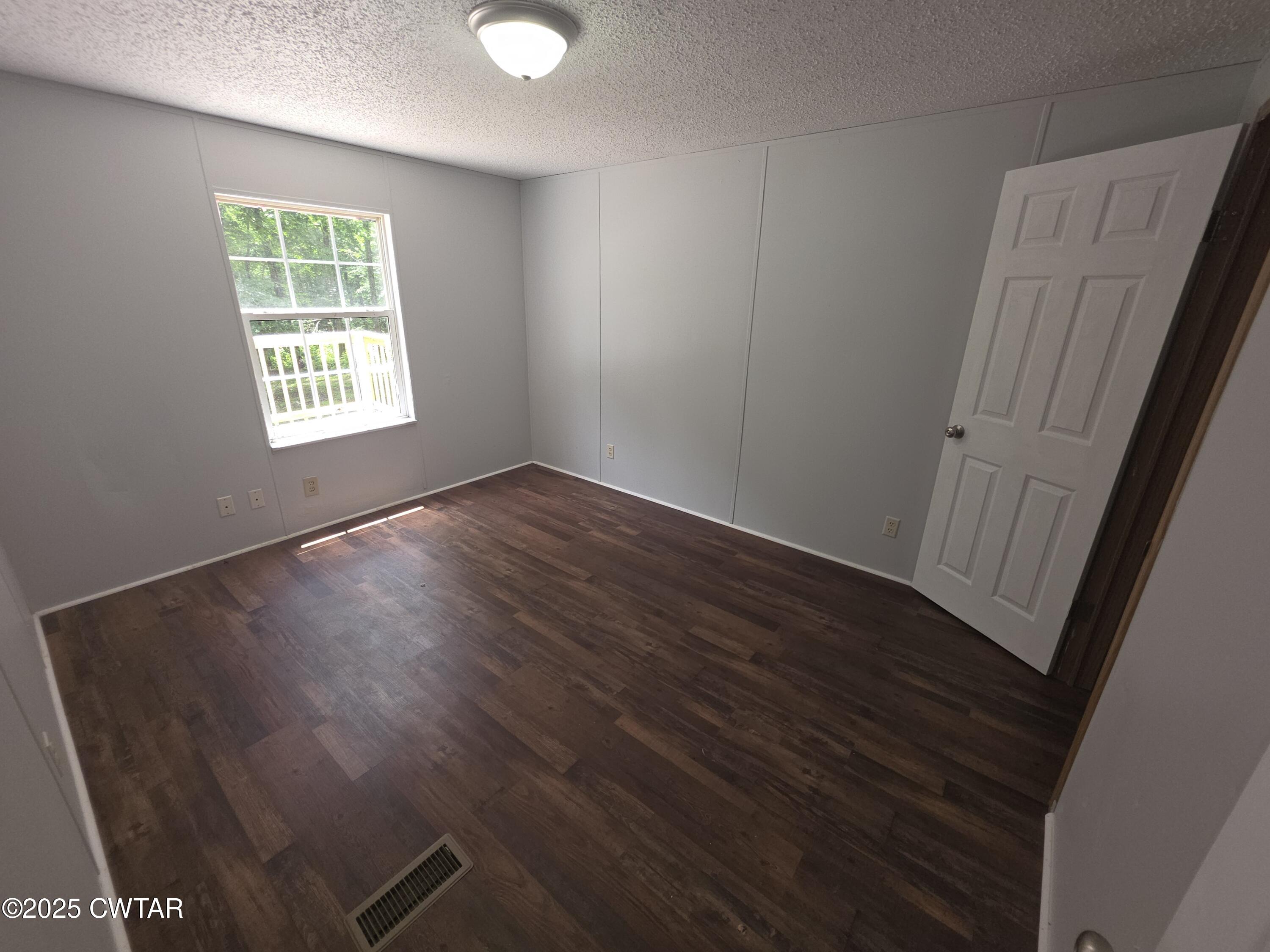 455 Liberty Road Beech Bluff, TN 38313 - Photo 29 of 63 an empty room with wooden floor and windows