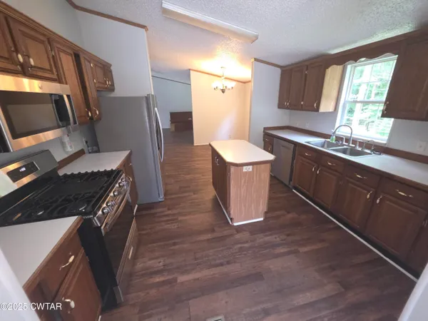 a kitchen with granite countertop wooden cabinets and a stove top oven
