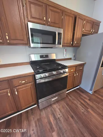 a kitchen with a refrigerator and wooden floor