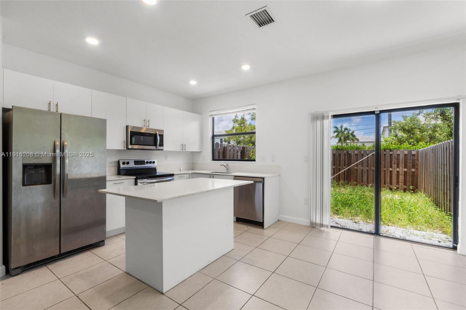 28637 Southwest 132nd Court Homestead, FL 33033 - Photo 16 of 45 a kitchen with white cabinets a sink dishwasher and a refrigerator