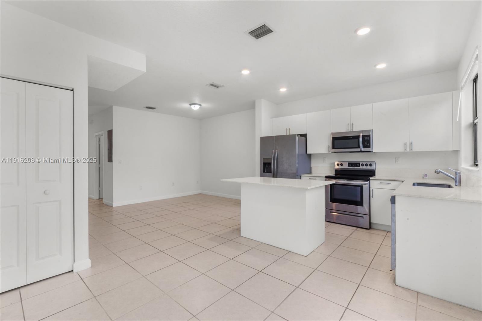 28637 Southwest 132nd Court Homestead, FL 33033 - Photo 20 of 45 a kitchen with white cabinets and stainless steel appliances