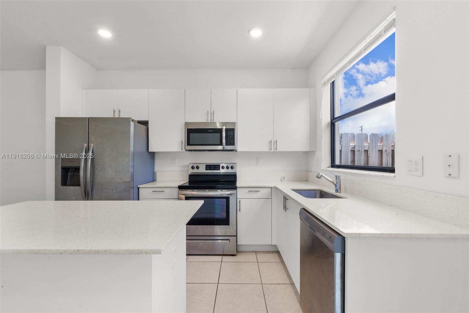 28637 Southwest 132nd Court Homestead, FL 33033 - Photo 22 of 45 a kitchen with a sink a stove a refrigerator a center island and a cabinets
