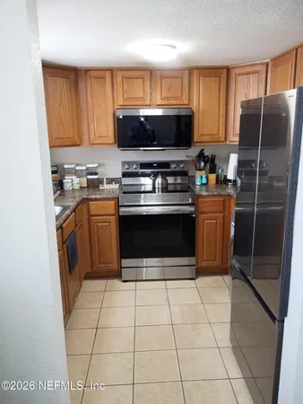 a kitchen with stainless steel appliances granite countertop a stove a sink dishwasher and a refrigerator