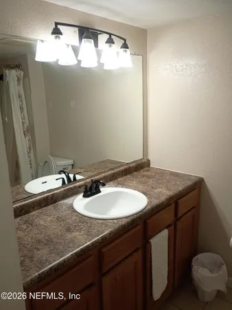 a bathroom with a granite countertop sink and a mirror