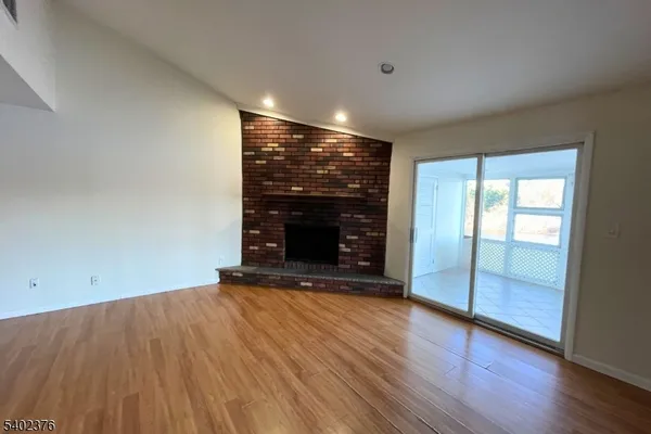 an empty room with wooden floor and fireplace