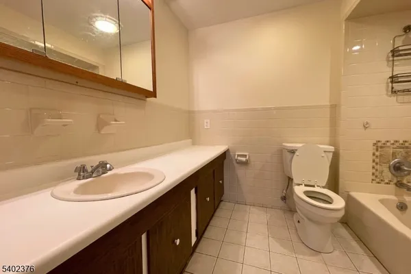 a bathroom with a granite countertop sink a toilet and a mirror