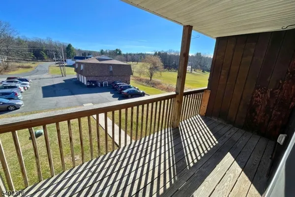 a view of a balcony with wooden floor and fence